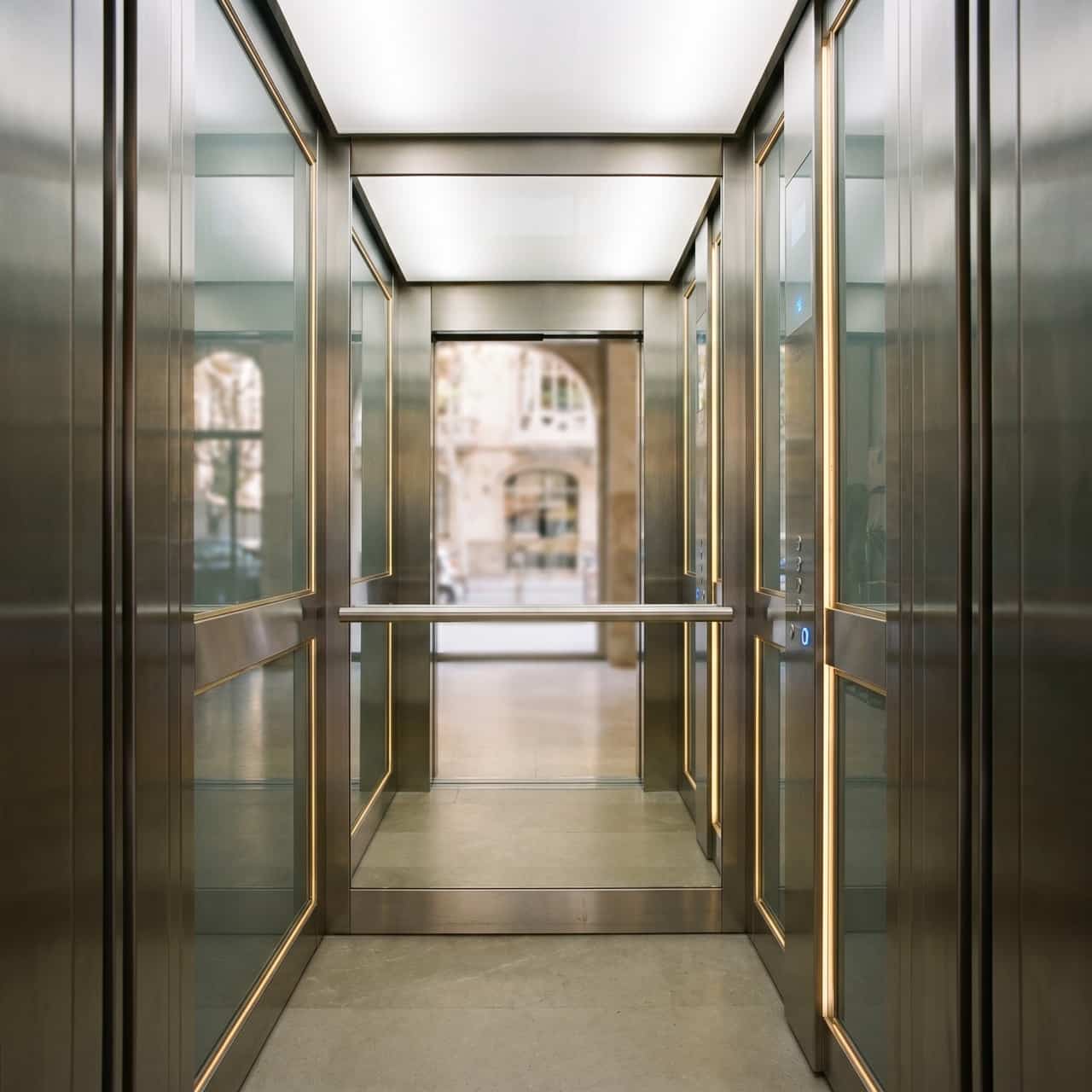 Interior d’una cabina d’ascensor modernitzada amb acabats nous, il·luminació LED i mirall en un edifici de Barcelona
